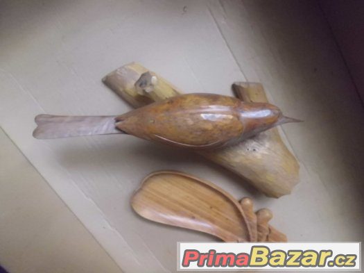 starý dřevěný vyřezávaný ptáček na větvi a dřevěná miska