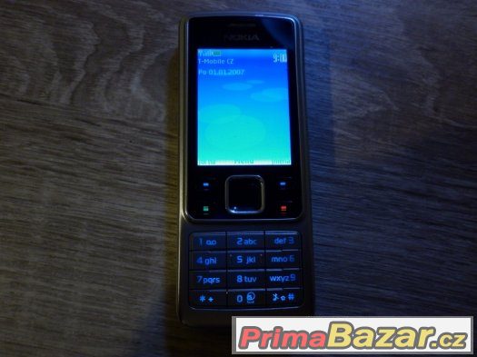 Nokia 6300, stříbrná,klasický tlačítkový telefon.