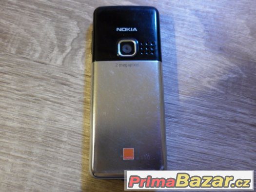 Nokia 6300, stříbrná,klasický tlačítkový telefon.
